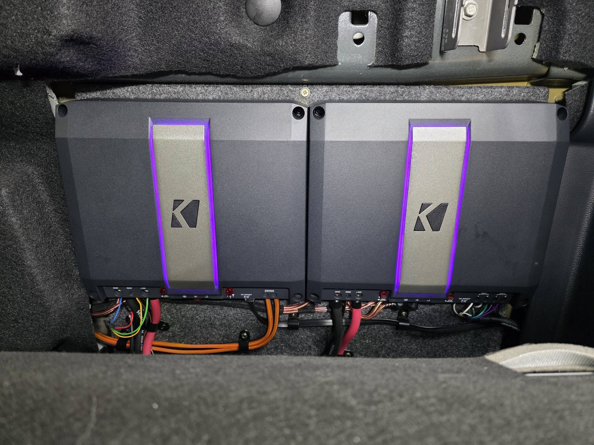 Two neatly mounted amplifiers with visible custom wiring